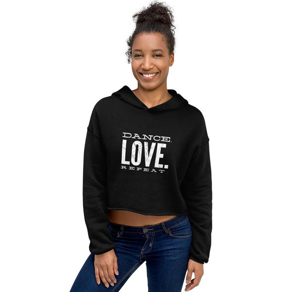 smiling woman wearing a black crop hoodie and jeans