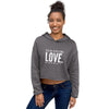 smiling woman wearing a grey crop hoodie and jeans